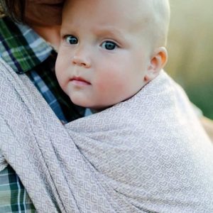 Bebé mirando a cámara mientras es porteado con el fular tejido little frog lovely heath