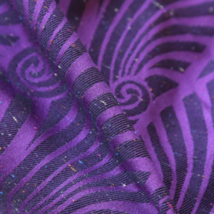 primer plano de la textura de la bandolera Yaro Dandy Purple Black, mostrando el patrón de remolinos olas morados sobre fondo negro con sutiles motas de colores