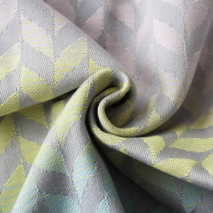 Primer plano del tejido de la mochila Buzzidil Baby Evolution Wings Summerbreeze, mostrando el patrón de espigas o alas en tonos pastel gris, amarillo y azul claro.