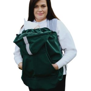 Mujer porteando a su bebé al aire libre con un fondo blanco bajo un cobertor de porteo de tejido softshell de la marca Little Frog en color verde.