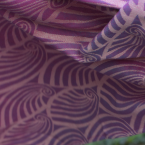 Primer plano de la textura de la bandolera Yaro, donde se aprecia el relieve del patrón Dandy y la trama de hilos rosas y blancos.