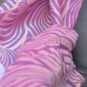 Caída de la tela de la bandolera Yaro, mostrando el contraste de colores entre el fucsia intenso y el blanco crudo en el reverso.