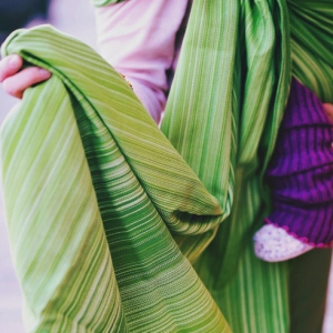 Detalle macro de la tela de la bandolera Little Frog Olivine, mostrando el patrón de rayas verdes que facilita el tensado punto por punto.