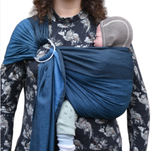 Madre porteando a su bebé en el pecho con una bandolera de anillas Yaro Blue Black (azul oscuro y negro), luciendo un estilo casual y resistente.