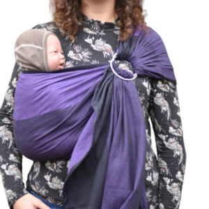 Madre porteando a su bebé en el pecho con una bandolera de anillas Yaro Purple Black, mostrando la profundidad del color morado oscuro y negro.