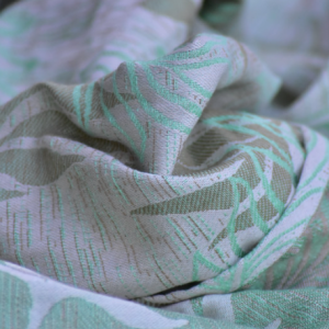 Montaña de pliegues del fular Yaro Oasis, revelando la calidad de una mezcla compleja de cuatro fibras naturales (Quad Blend).