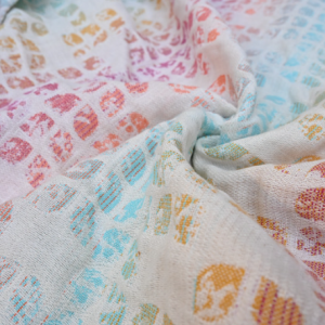 Primer plano de los pliegues del fular Yaro Petals, mostrando la textura rica de una mezcla de cuatro fibras naturales (Quad Blend).