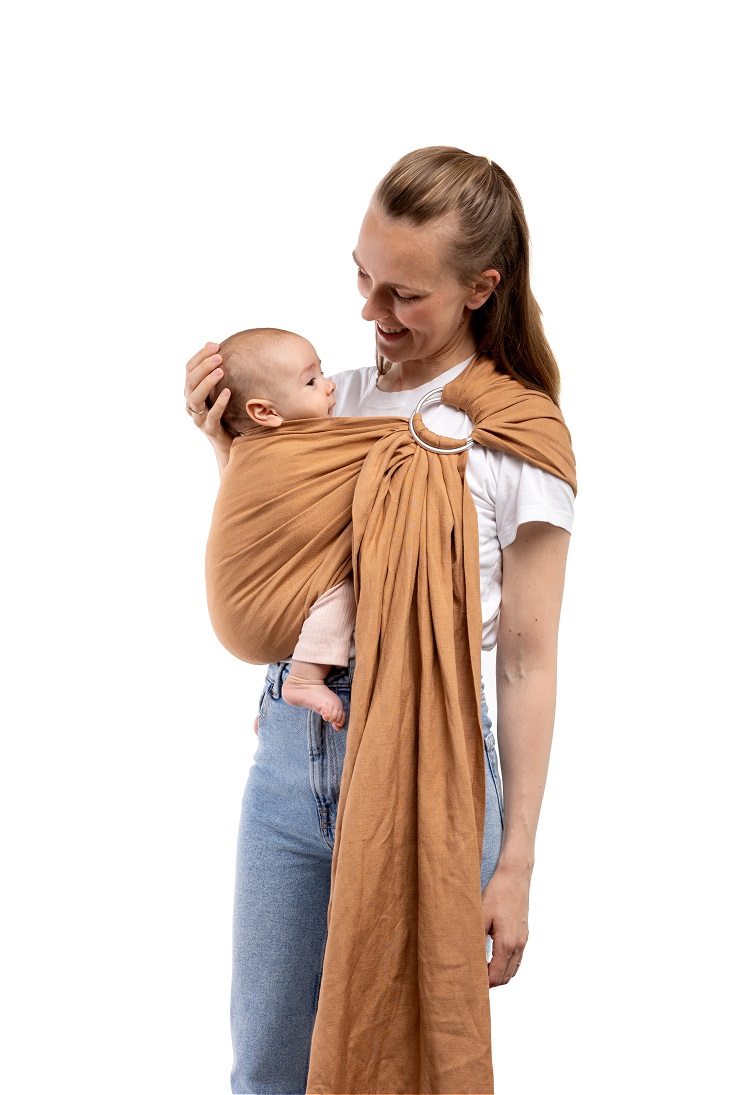 Fotografía con fondo blanco de catálogo de madre mostrando la postura y la caída de la tela de la bandolera de anillas Boba Ring Sling Rye Brown.
