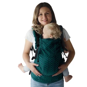 Fotografía recortada con fondo blanco de madre con bebé en la mochila evolutiva verde Little Frog Prime V3 Viridian Miles, ideal para tienda online.