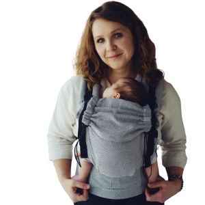 Fotografía recortada con fondo blanco de madre porteando a su recién nacido en la mochila evolutiva Little Frog Prime Zen Path, óptima para ficha de producto.